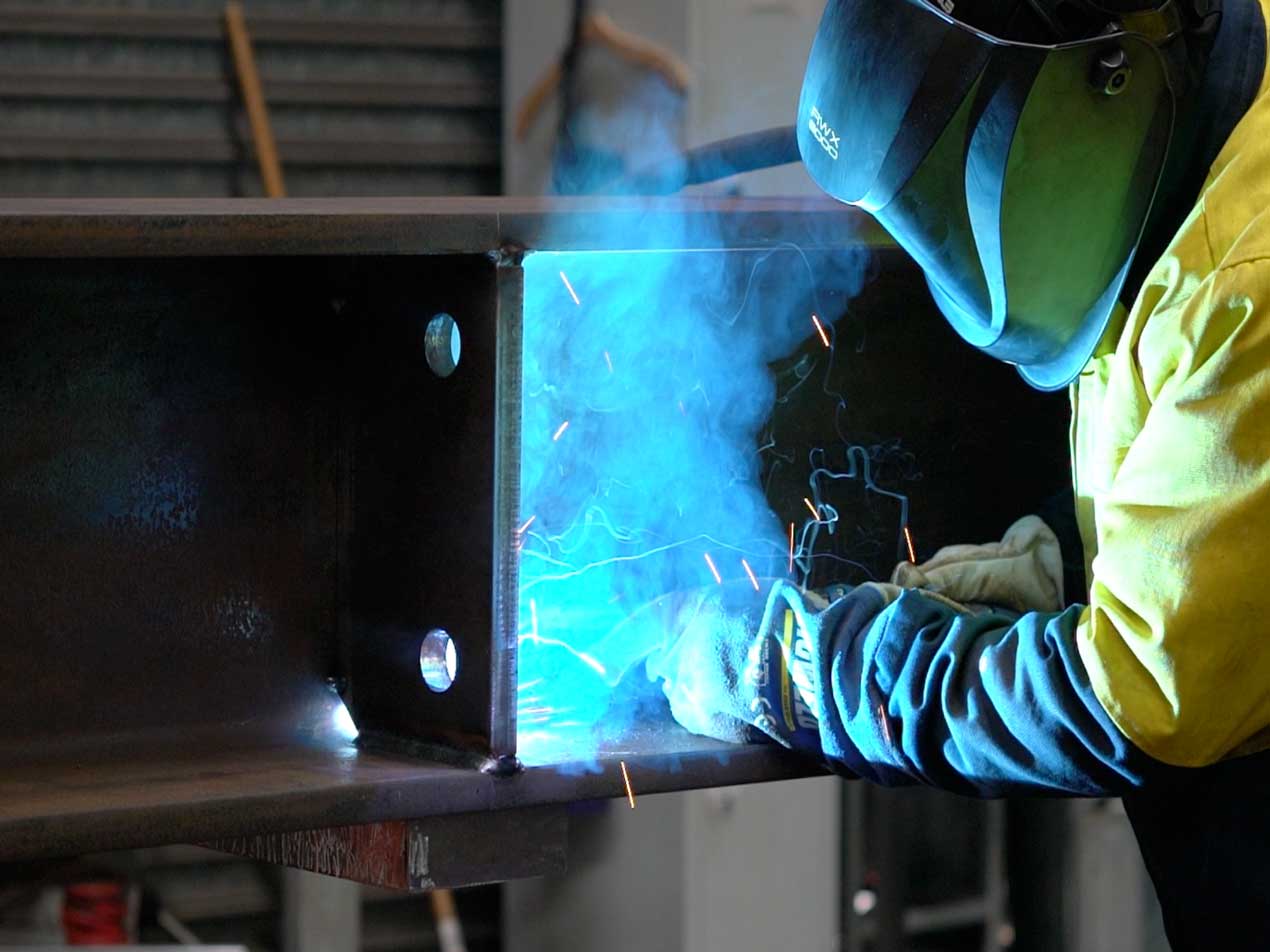 A manufacturing team member welding a product